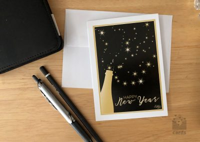 Golden wine bottle spilling stars on to a gold framed black background. Text reads "Happy New Year"
